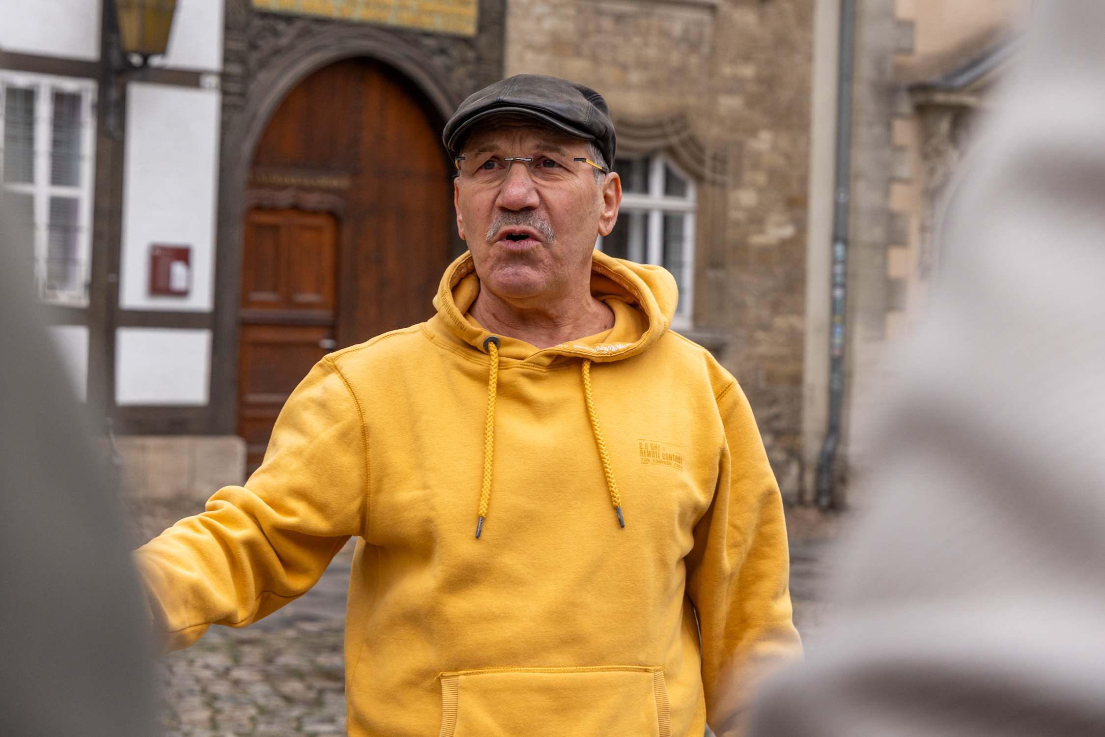Hans-Dietrich Haacke ist mit Teilnehmern seiner Stadtführung in Braunschweig auf dem Burgplatz und erzählt fakten und Anekdoten über Braunschweig.