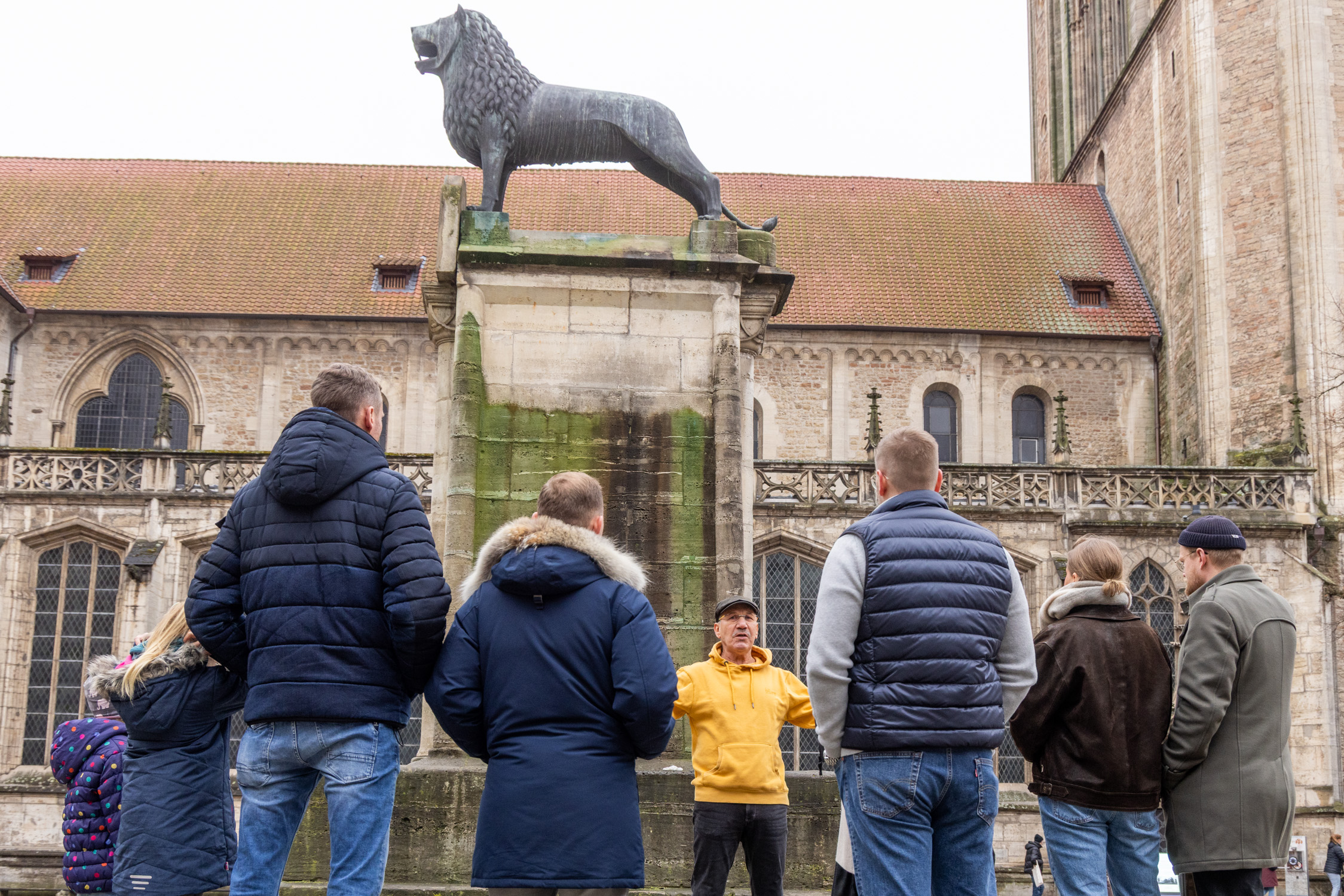 Hans-Dietrich Haacke ist mit Teilnehmern seiner Stadtführung in Braunschweig auf dem Burgplatz und erzählt fakten und Anekdoten über Braunschweig.